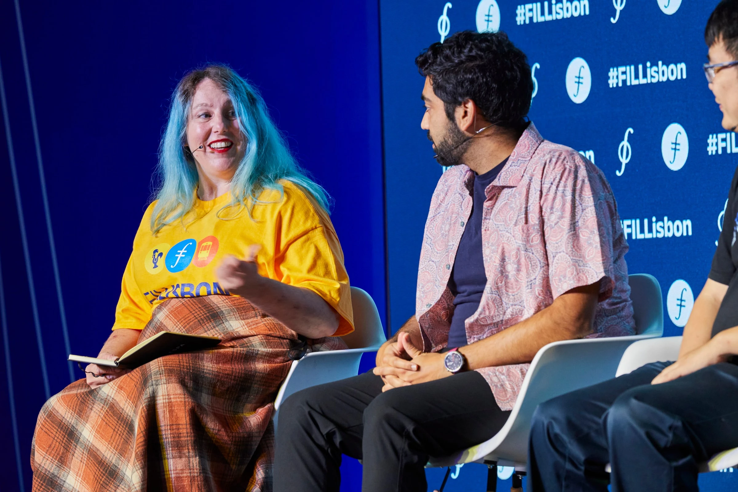 A fireside conversation on the FIL Lisbon stage in front of a branded backdrop
